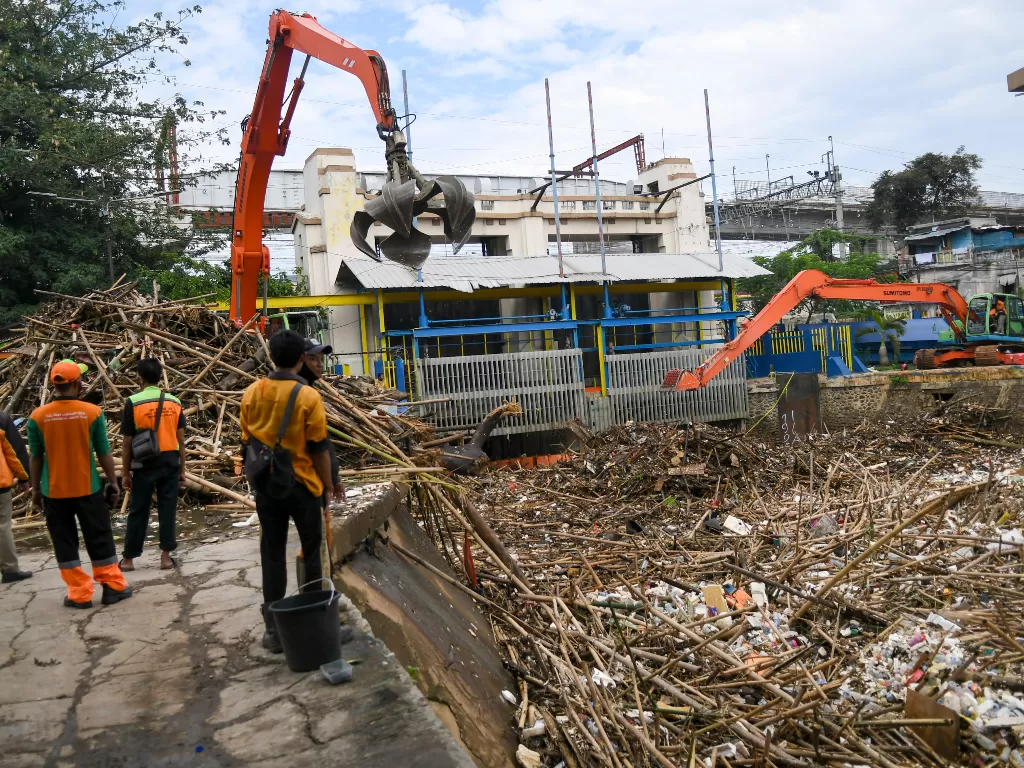 Petugas Dinas Kebersihan DKI Jakarta menggunakan alat berat membersihkan sampah di pintu air Manggarai, Jakarta, Selasa (22/9/2020). (Foto: ANTARA/Galih Pradipta)