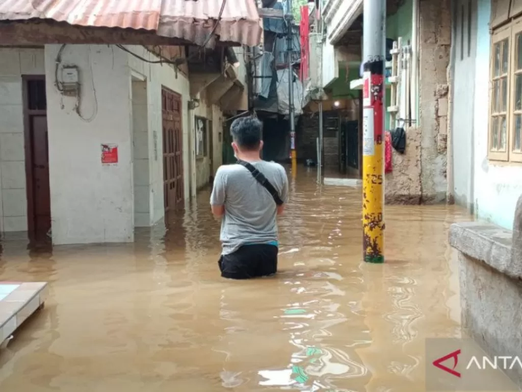 Warga Kebon Pala, Kampung Melayu, Jatinegara, Jakarta Timur, melintas di RT 11/RW 05 yang terendam banjir dengan ketinggian berkisar 50-70 sentimeter, Selasa (22/9/2020) pagi. (Foto: ANTARA/Andi Firdaus).