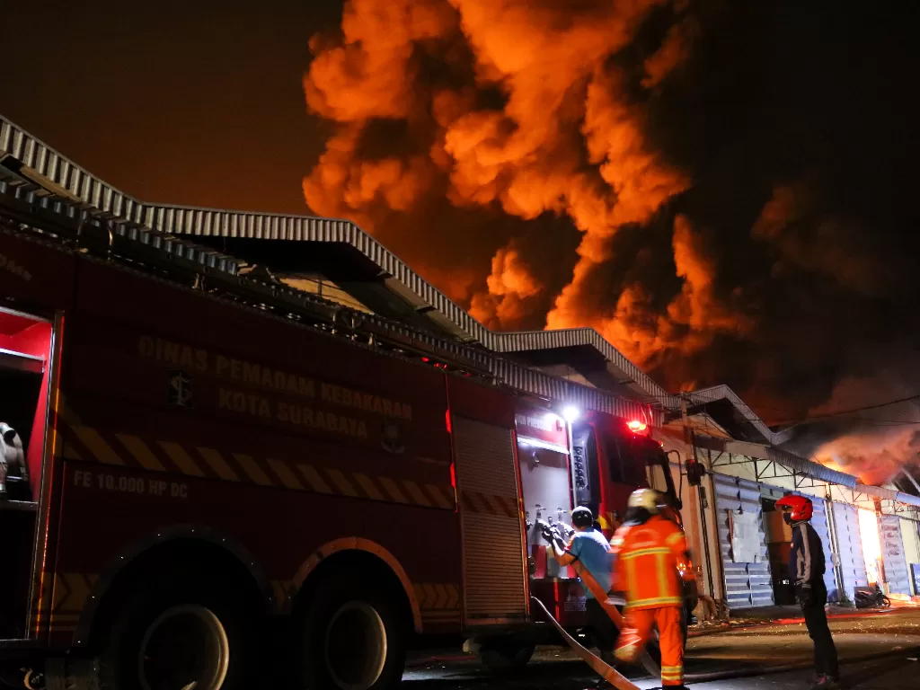 Petugas Dinas Pemadam Kebakaran Kota Surabaya memadamkan gudang yang terbakar di kompleks pergudangan Margomulyo Jaya (ANTARA FOTO/Didik Suhartono)