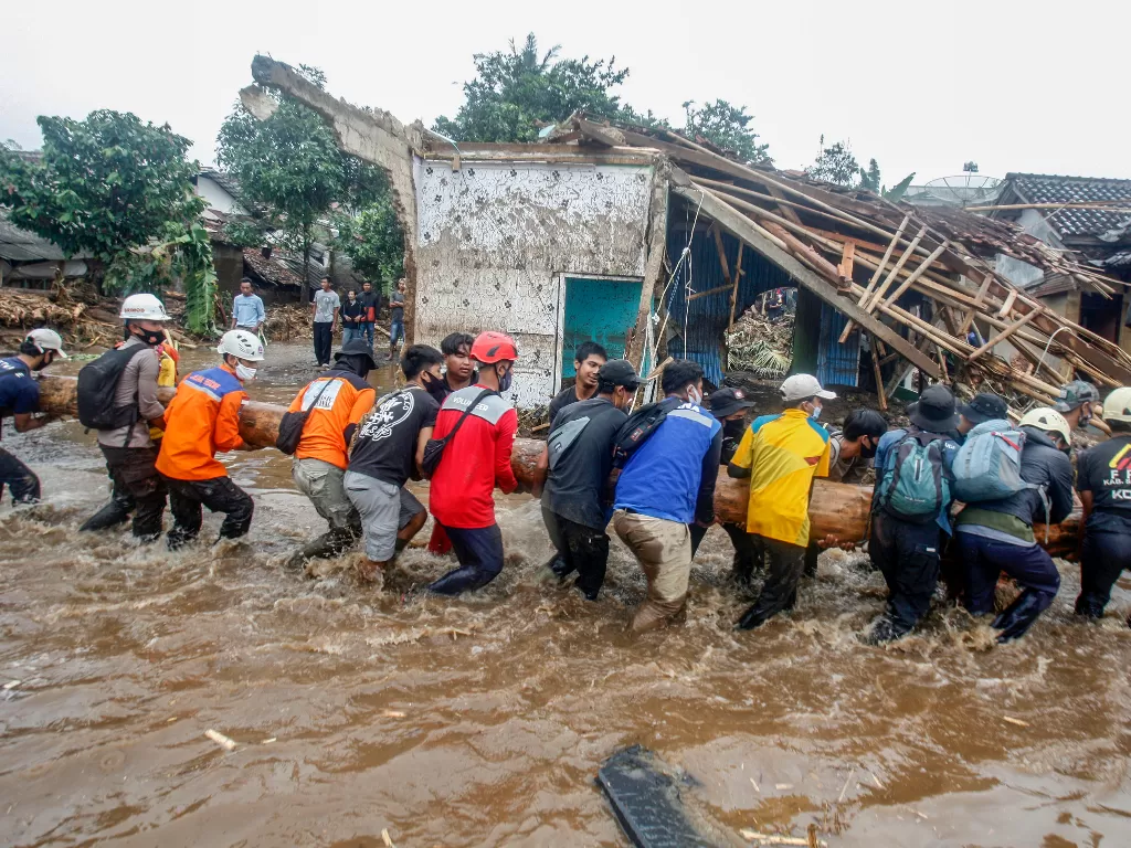 Sejumlah relawan gabungan mengevakuasi material kayu yang terbawa banjir bandang di Kampung Cibuntu, Desa Pasawahan, Kecamatan Cicurug, Sukabumi, Jawa Barat, Selasa (22/9/2020). (ANTARA FOTO/Yulius Satria Wijaya)