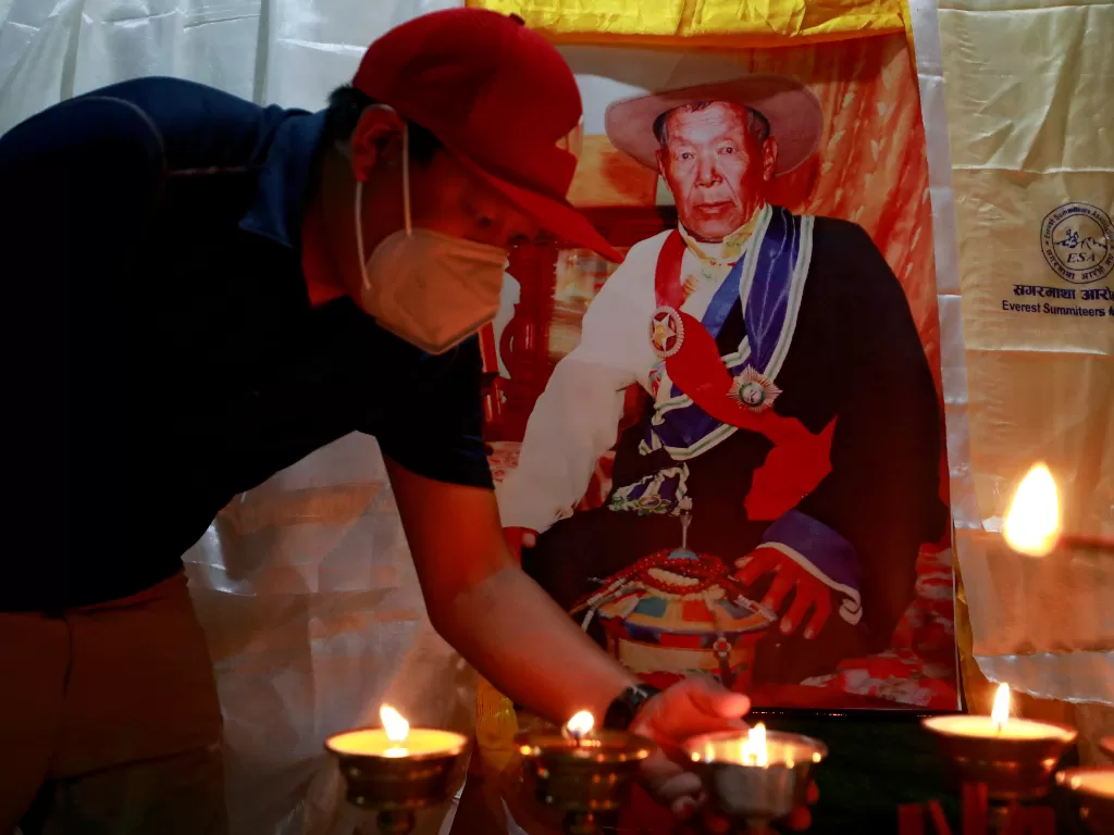 Seorang anggota keluarga menawarkan lampu mentega di dekat tubuh Ang Rita Sherpa (REUTERS/Navesh Chitrakar)
