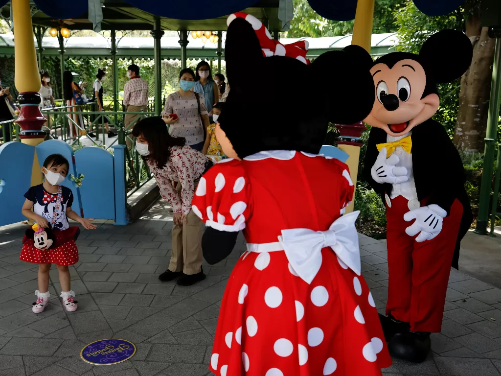 Seorang anak menyambut karakter Disney Mickey Mouse dan Minnie Mouse (REUTERS/Tyrone Siu)