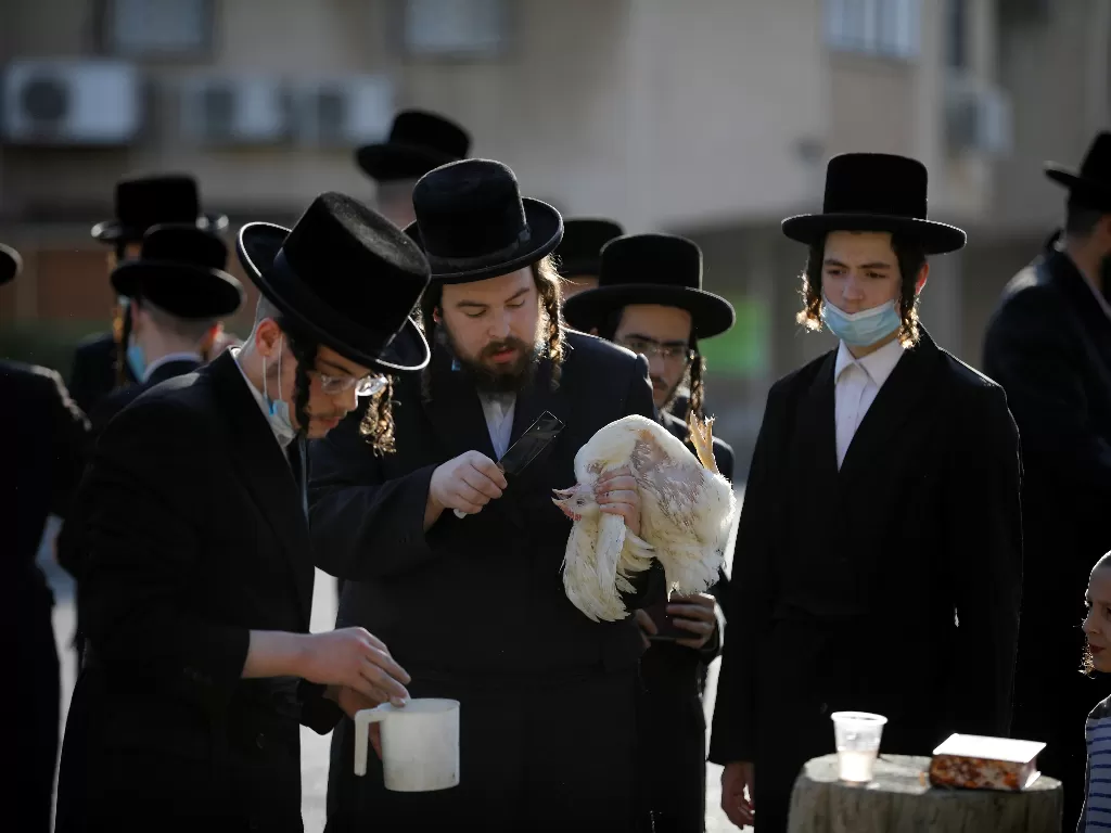 Ultra-Ortodoks Yahudi melakukan ritual Kaparot, di mana ayam putih disembelih sebagai isyarat simbolis penebusan (REUTERS/Amir Cohen)