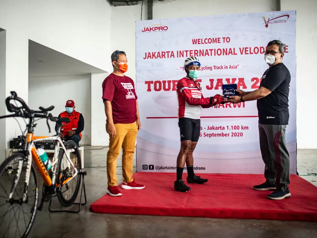 Mantan Atlet Sepeda Nasional Tarwi (tengah) menerima cendera mata dari Direktur Operasi PT Jakarta Propertindo (Jakpro) Muhammad Taufiqurrachman (kanan) disaksikan Direktur Utama PT LRT Jakarta Wijanarko (kiri) seusai finis dari perjalanan Tour De Java 1.