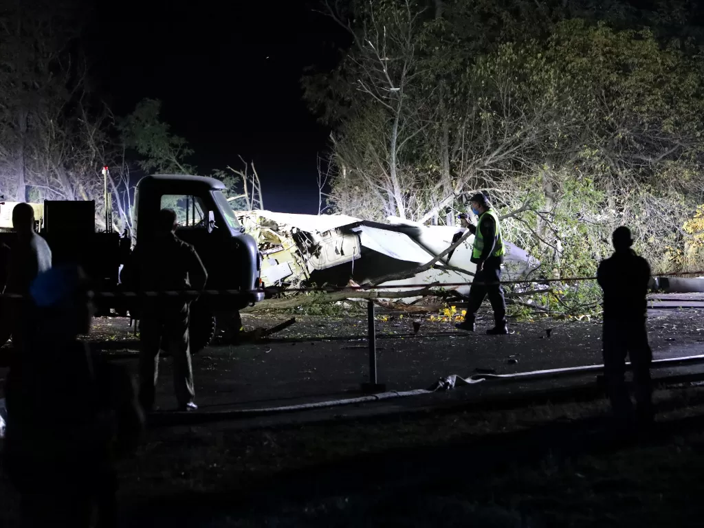 Tim penyelamat memeriksa puing-puing pesawat militer Ukraina Antonov An-26 setelah jatuh di luar kota Chuhuiv, Ukraina (REUTERS/Vyacheslav Madiyevskyy)