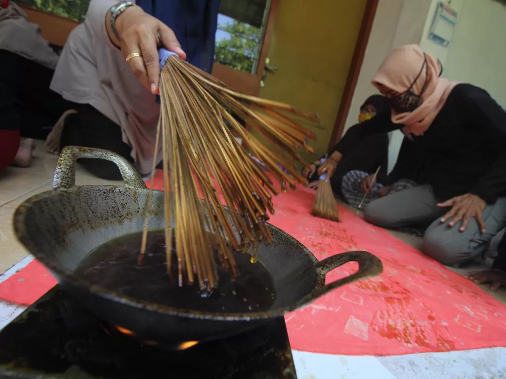 Perajin membuat batik sapu lidi di kawasan Jetis Kulon, Surabaya, Jawa Timur, Minggu (27/9/2020). ANTARA FOTO/Didik Suhartono