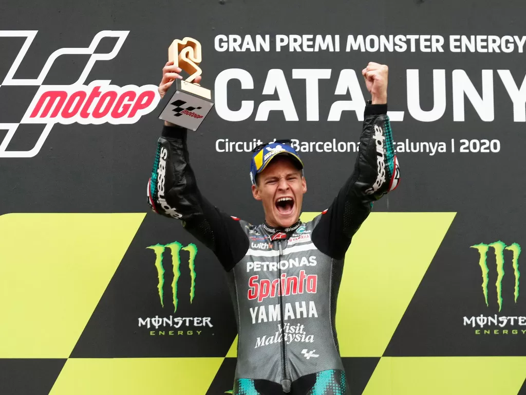 Fabio Quartararo dari Petronas Yamaha SRT merayakan dengan trofi di podium setelah memenangkan perlombaan (REUTERS/Albert Gea)