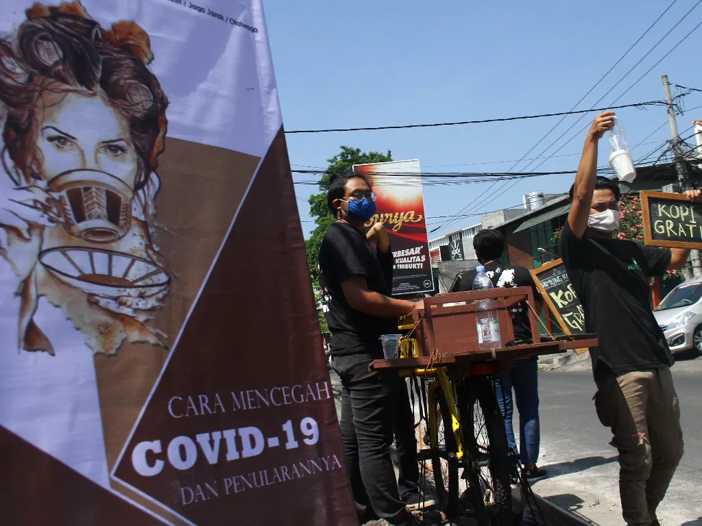 Barista meracik kopi untuk dibagikan gratis kepada pengguna jalan dalam peringatan Hari Kopi Internasional di jalan Siguragura, Malang, Jawa Timur, Kamis (1/10/2020). ANTARA FOTO/Ari Bowo Sucipto