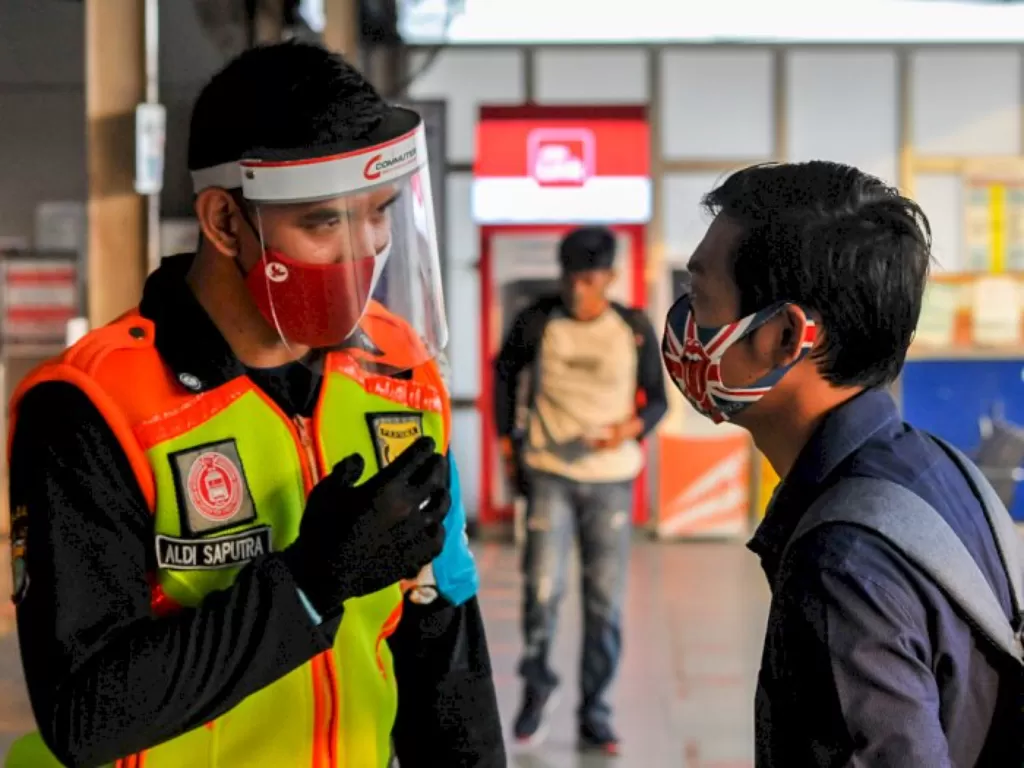 Petugas keamanan menegur calon penumpang Kereta Rel Listrik Commuter Line yang menggunakan masker jenis scuba (ANTARA FOTO/Fakhri Hermansyah)