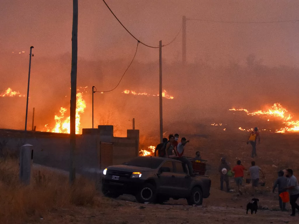 Orang-orang menyaksikan kebakaran yang membakar di La Candelaria, di provinsi Cordoba, Argentina 30 September 2020 (REUTERS/Charly Soto)