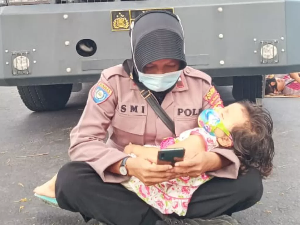 Viral polwan gendong anak saat jaga demo pilkada di Dompu. (Dok. Istimewa)