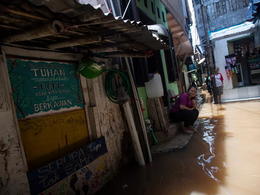 Warga menunggu air surut saat banjir melanda kawasan permukiman di Petogogan, Kebayoran Baru, Jakarta Selatan, Senin (5/10/2020). ANTARA FOTO/Sigid Kurniawan