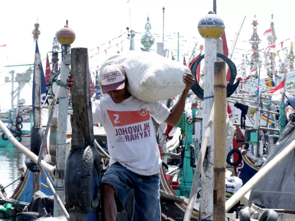 Nelayan memanggul barang bawaannya di Pelabuhan Ikan Muncar Banyuwangi, Jawa Timur, Jumat (2/10/2020). (Photo/ANTARA FOTO/Budi Candra Setya)