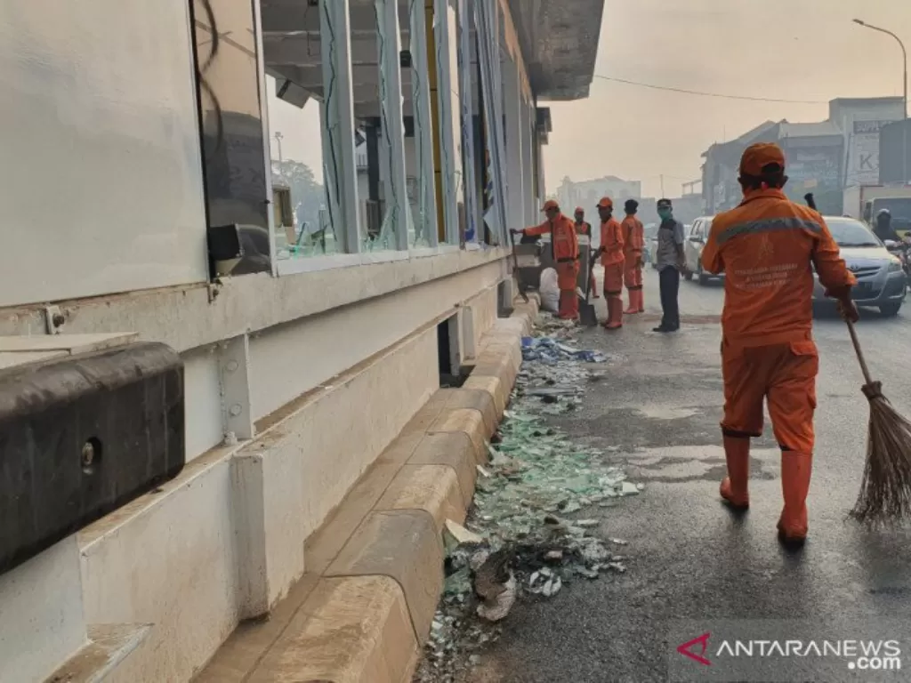 Petugas PPSU Kelurahan Kramat menyapu jalan yang masih dipenuhi pecahan kaca dari Halte Senen, Jumat (9/10/2020). (ANTARA/Livia Kristianti)