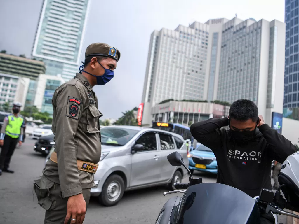 Petugas kepolisian menggelar pemeriksaan kepatuhan PSBB di kawasan Bundaran HI, Jakarta. (ANTARA/Hafidz Mubarak A)