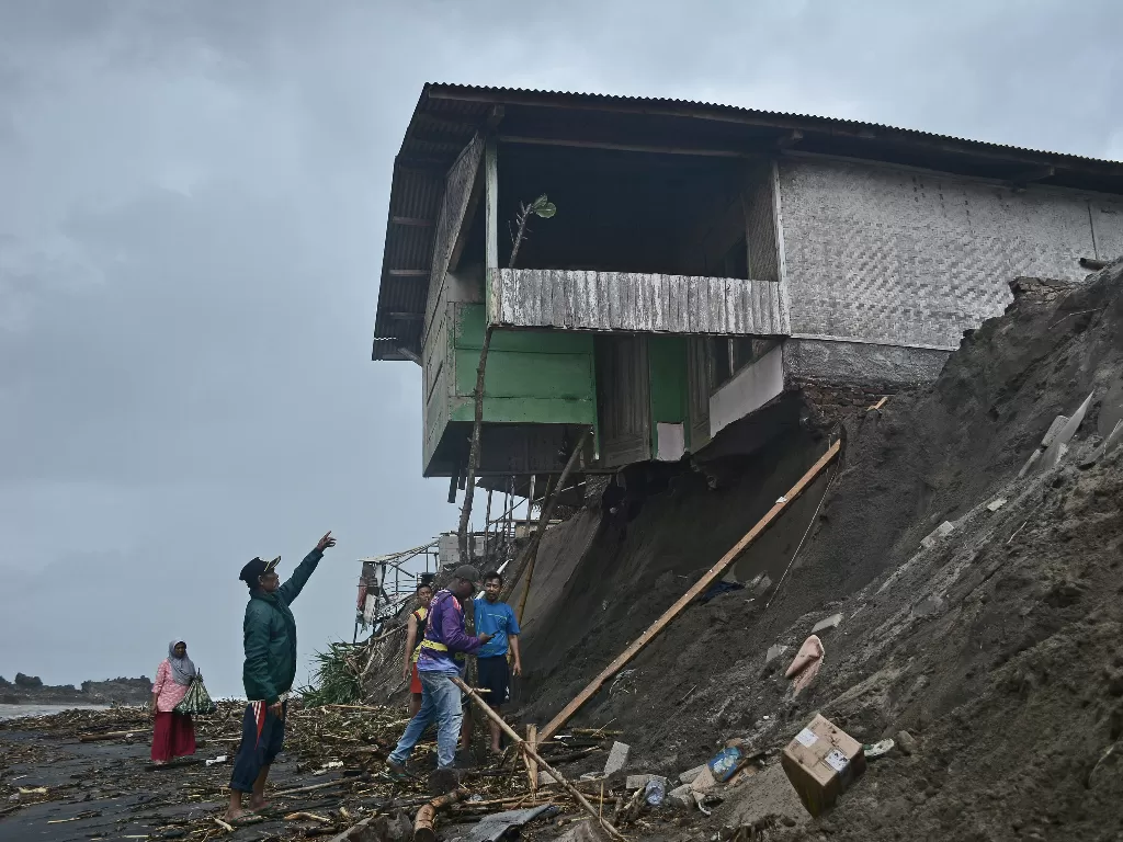 Warga memeriksa kondisi rumah yang hampir runtuh akibat banjir bandang di kawasan Pantai Karang Paranje (ANTARA FOTO/Candra Yanuarsyah)