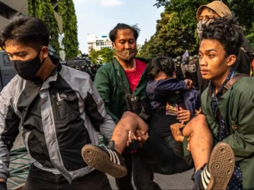 Sejumlah mahasiswa menggotong rekannya yang terluka saat berunjuk rasa menolak RUU Cipta Kerja Omnibus Law yang telah disahkan oleh DPR RI di depan gedung DPRD Jateng, Kota Semarang, Jawa Tengah, Rabu (7/10/2020). (ANTARA FOTO/AJI STYAWAN)