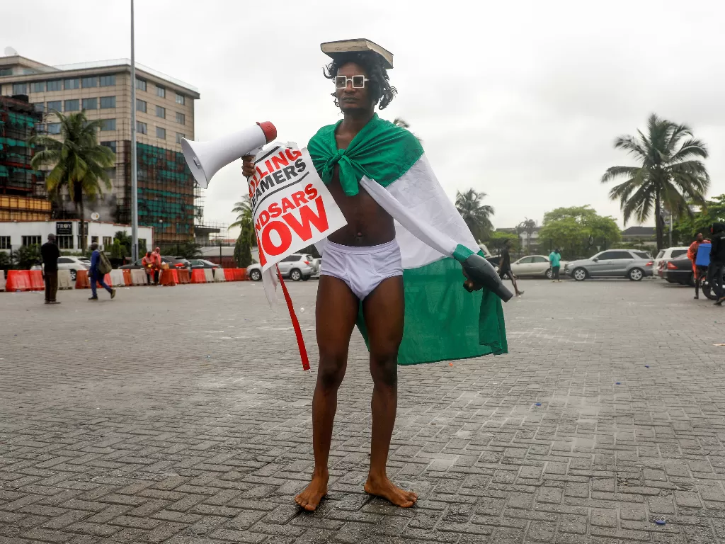 Seorang demonstran dengan pakaian dalam membawa pengering rambut dan megafon selama protes atas dugaan kebrutalan polisi, di Lagos, Nigeria (REUTERS/Temilade Adelaja)