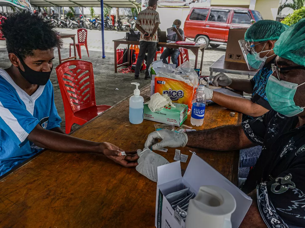 Petugas mengambil sampel darah seorang warga di posko Dinas Kesehatan (Dinkes) Provinsi Papua, Kota Jayapura, Kamis (15/10/2020). ANTARA FOTO/Indrayadi TH 