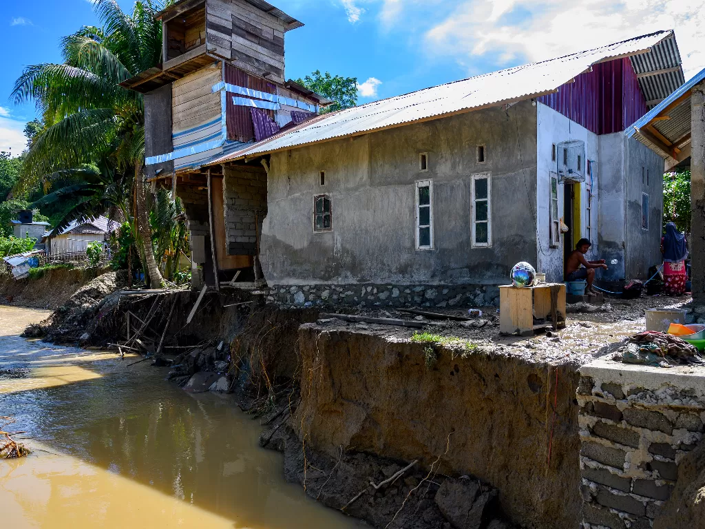 Warga duduk di depan rumahnya yang nyaris ambruk diterjang banjir akibat luapan sungai di Desa Lumbudolo, Kecamatan Banawa Tengah, Kabupaten Donggala, Sulawesi Tengah, Jumat (16/10/2020). ANTARAFOTO/Basri Marzuki