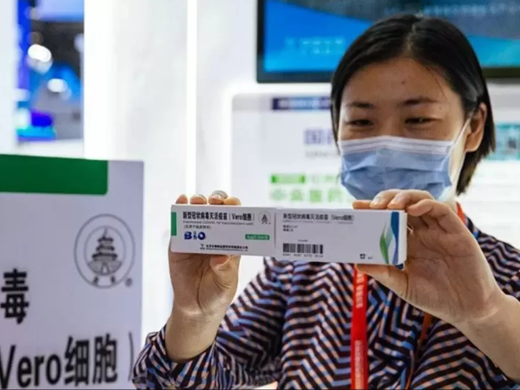 Penjaga stan pameran Ciftis di Beijing, Jumat (4/9/2020), menunjukkan dua kandidat vaksin COVID-19 buatan Sinopharm dan Sinovac. (Photo/ANTARA/HO-GT/Li Hao)