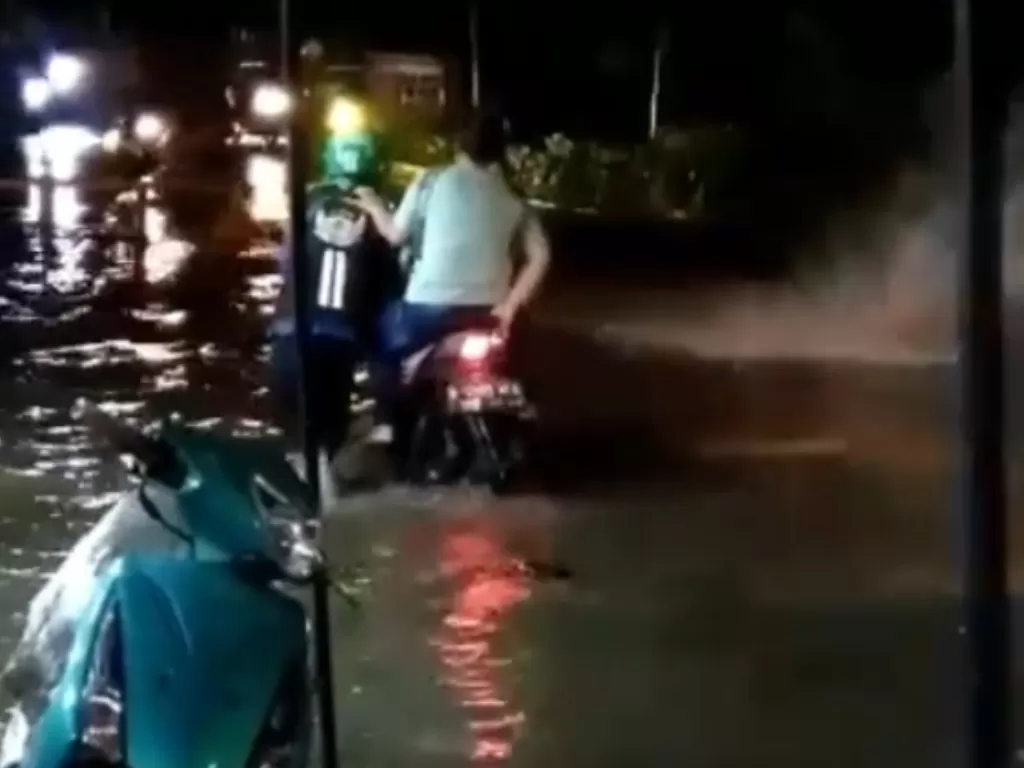Driver ojol terobos banjir sambil tuntun motor dan penumpangnya (Instagram/@dramaojol.id)