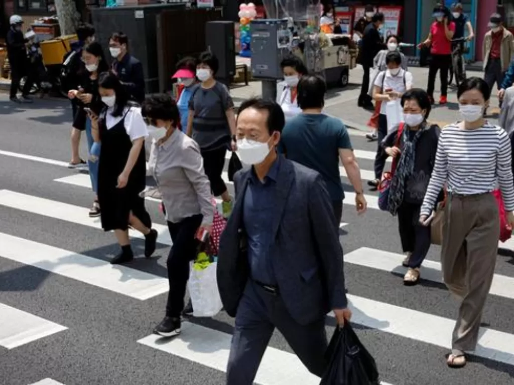 Para pejalan kaki menggunakan masker untuk cegah penularan Covid-19 di Seoul, Korea Selatan, Rabu (22/7/2020). (REUTERS/Kim Hong-Ji)