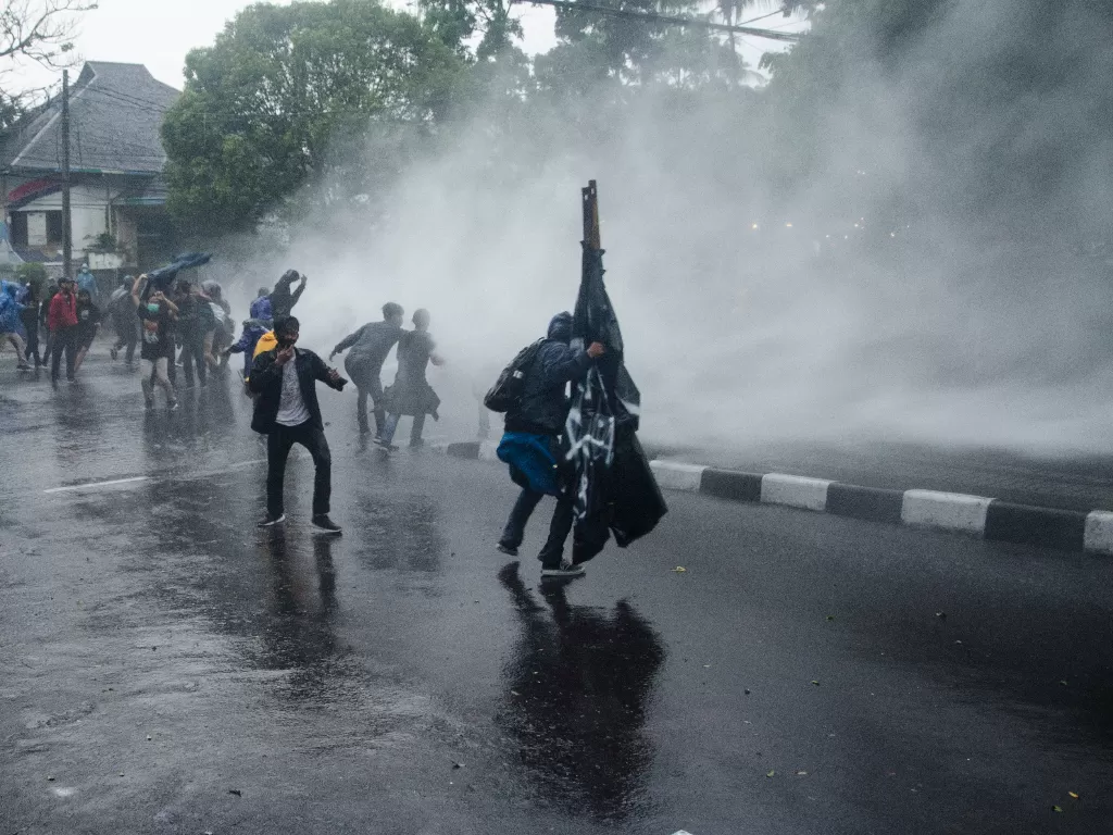 Demonstran menghalau datangnya meriam air yang ditembakkan petugas kepolisian (ANTARA FOTO/Novrian Arbi)