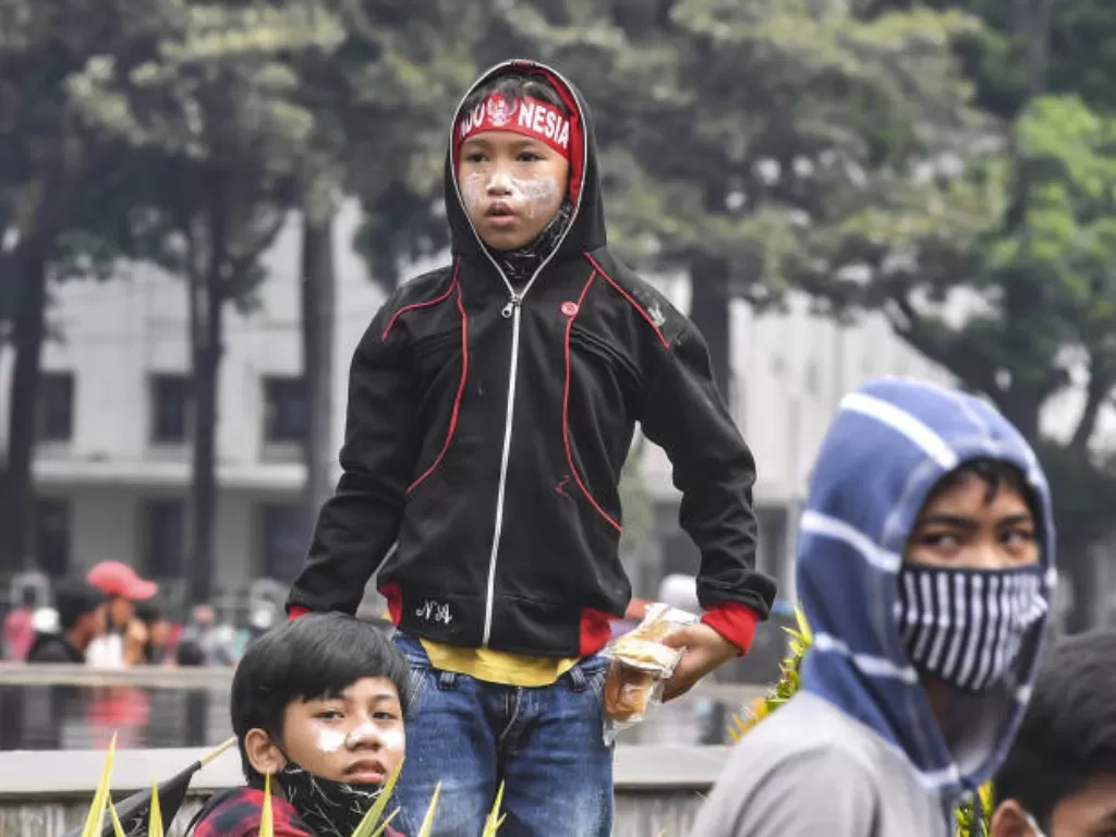 Anak di bawah umur mengikuti aksi tolak UU Cipta Kerja di kawasan Patung Kuda, Jakarta, Selasa (13/10/2020). (ANTARA FOTO/Muhammad Adimaja)