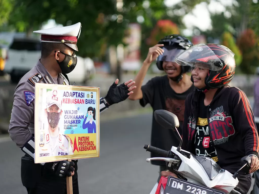 Anggota polisi lalu lintas memberikan imbauan mengenai protokol kesehatan (ANTARA FOTO/Adiwinata Solihin)