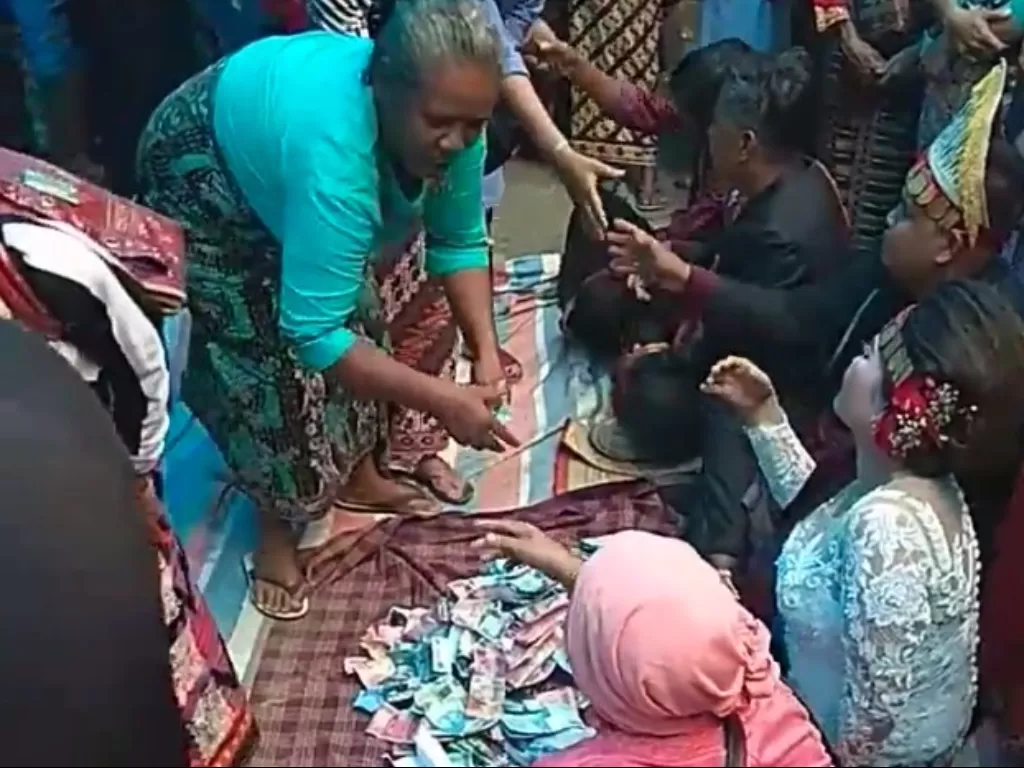 Pesta pernikahan adat Batak, salami mempelai dengan uang. (Facebook/Rudianto)
