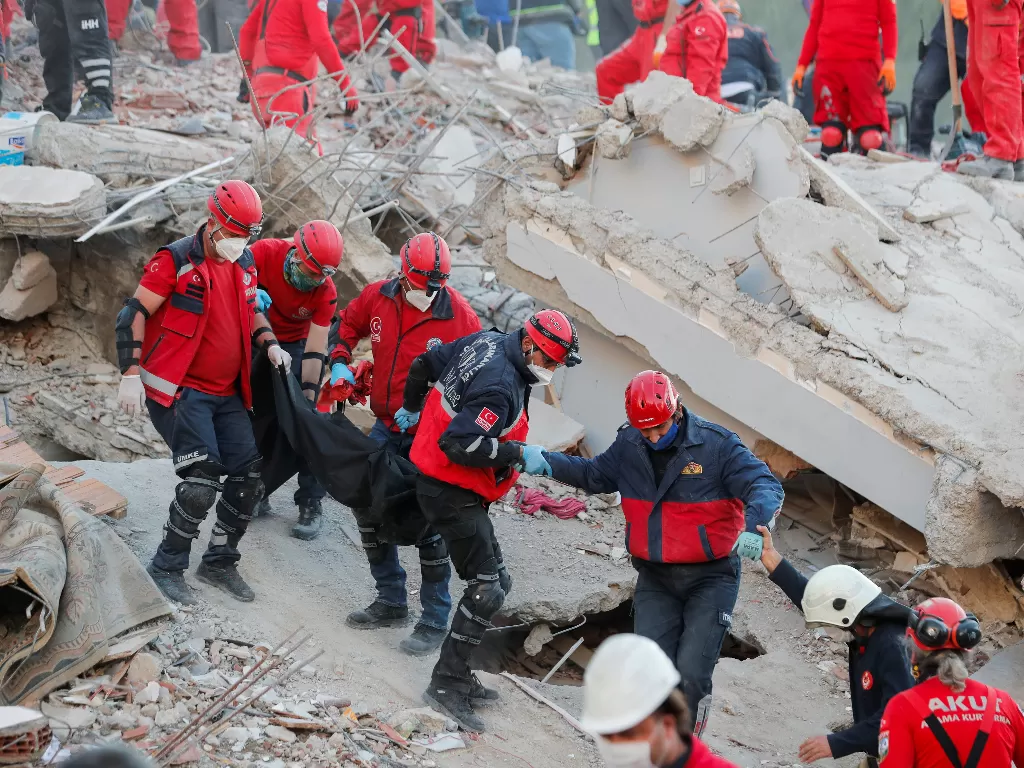 Para pekerja membawa jenazah korban saat operasi penyelamatan terjadi di sebuah lokasi setelah gempa bumi melanda Laut Aegea (REUTERS/Murad Sezer)