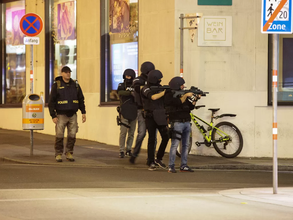 Petugas polisi mengarahkan senjata mereka di sudut jalan setelah baku tembak di Wina, Austria (REUTERS/Lisi Niesner)