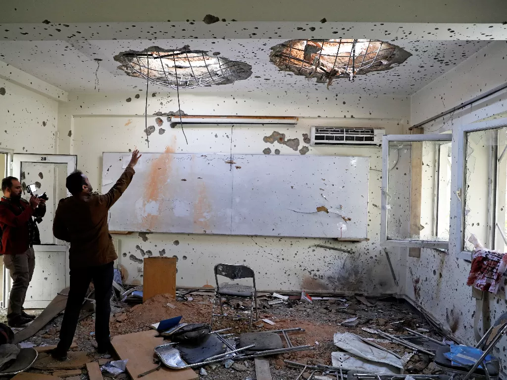 Wartawan Afghanistan merekam film di dalam ruang kelas setelah serangan kemarin di Universitas Kabul, Afghanistan (REUTERS/Mohammad Ismail)