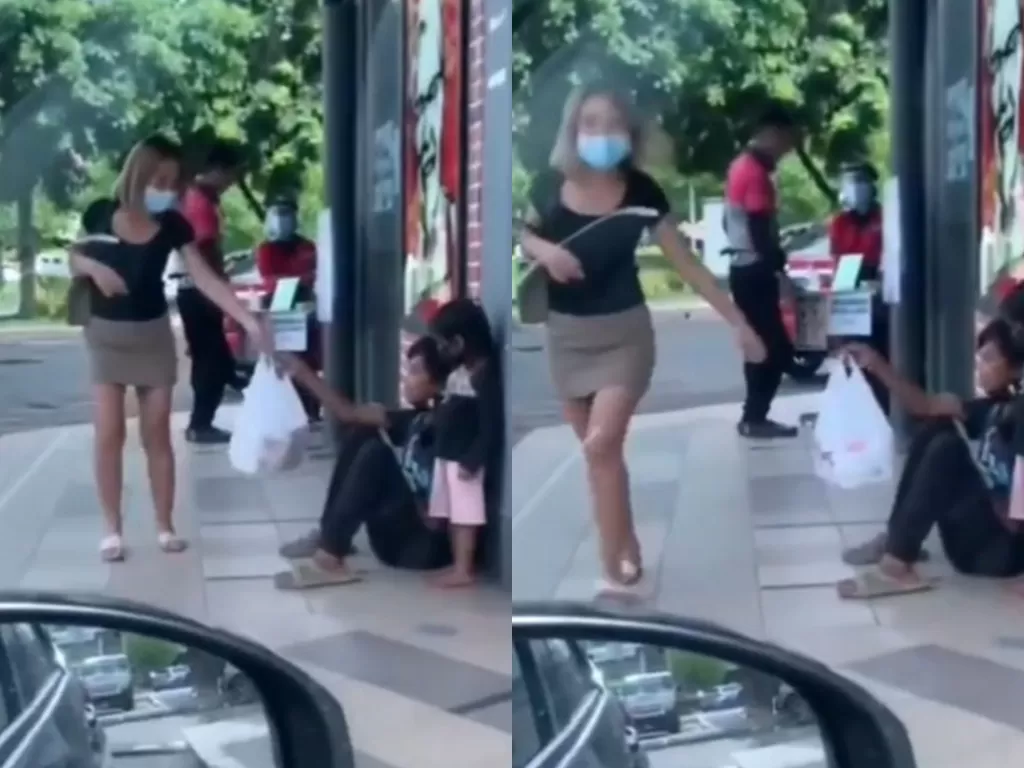 Seorang wanita memberikan ayam goreng kepada anak jalanan. (Tangkapan layar)