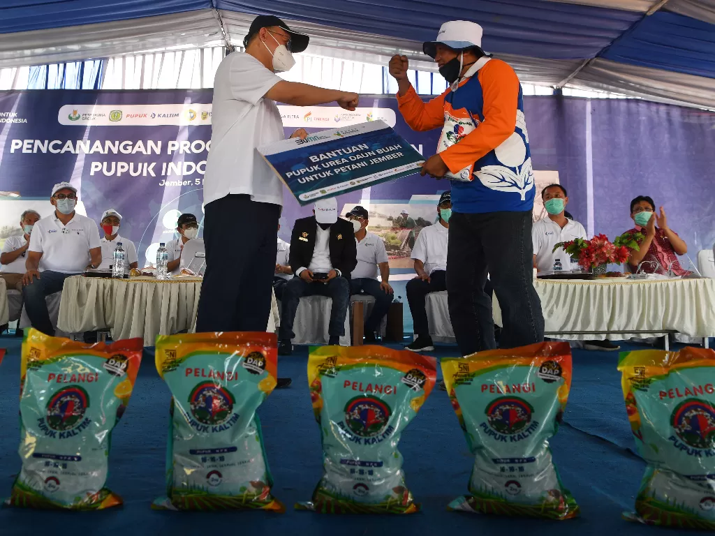 Direktur Utama PT Pupuk Indonesia (Persero) Bakir Pasaman (kiri) memberikan bantuan pupuk kepada seorang perwakilan petani saat Pencananan Program Nasional Agro Solution PT Pupuk Indonesia (Persero) di Jember, Jawa Timur, Kamis (5/11/2020). ANTARA FOTO/Za
