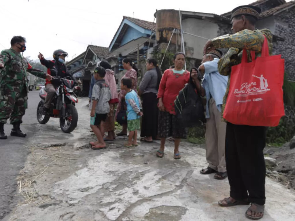 Personel TNI membantu warga menuju tempat pengungsian di kawasan lereng Gunung Merapi di Desa Krinjing, Dukun, Magelang, Jawa Tengah, Jumat (6/11/2020). (ANTARA FOTO/Taufiq R)