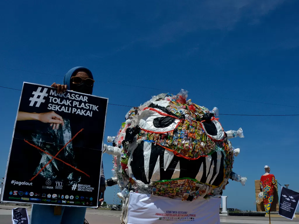 Aktivis lingkungan membentangkan poster dan membuat replika monster dari sampah plastik (ANTARA FOTO/Abriawan Abhe)