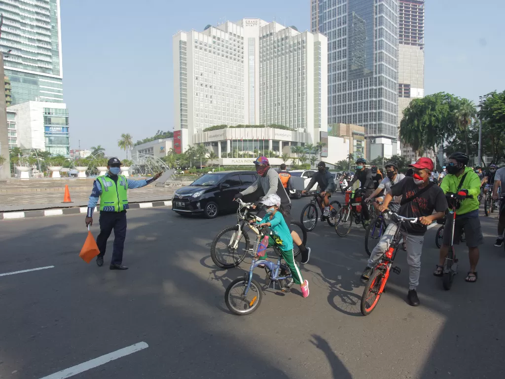 Warga bersepeda dengan mengenakan masker saat hari bebas kendaaran bermotor pada masa transisi PSBB di kawasan Bundaran HI, Jakarta, Minggu (8/11/2020).  (photo/ANTARA FOTO/ Reno Esnir)