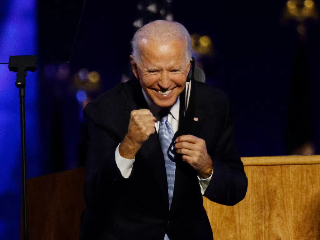 Capres AS dari Partai Demokrat 2020 Joe Biden merayakan kemenangan di atas panggung di Wilmington, Delaware, AS setelah media berita mengumumkan bahwa Biden menang. (REUTERS/Jim Bourg)