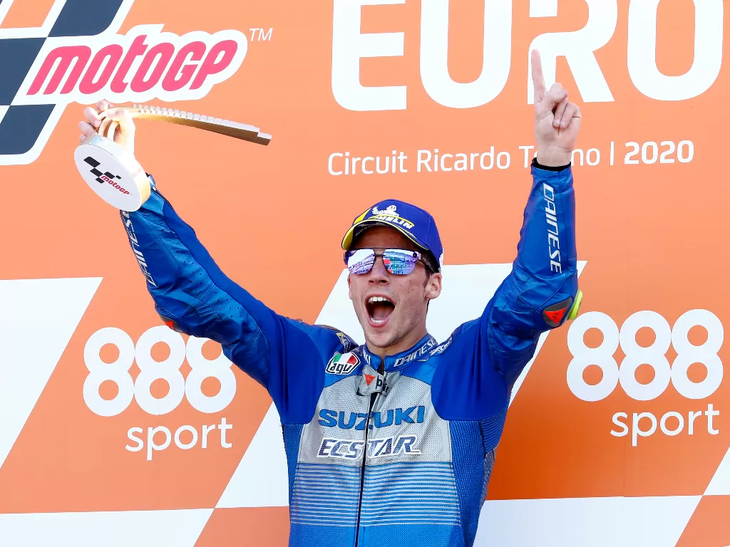 Joan Mir dari tim Suzuki Ecstar merayakan dengan trofi di podium setelah memenangkan perlombaan (REUTERS/Juan Medina)