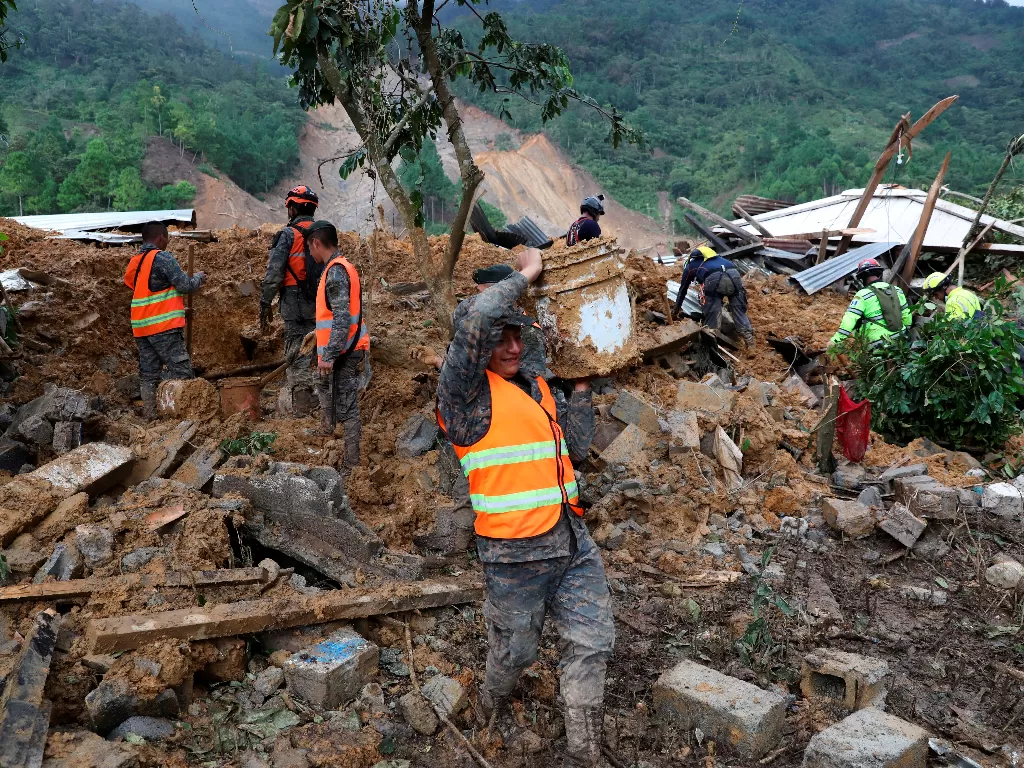 Tentara membersihkan puing-puing dan lumpur dari daerah yang dilanda tanah longsor (REUTERS/Esteban Bilba/EFE)