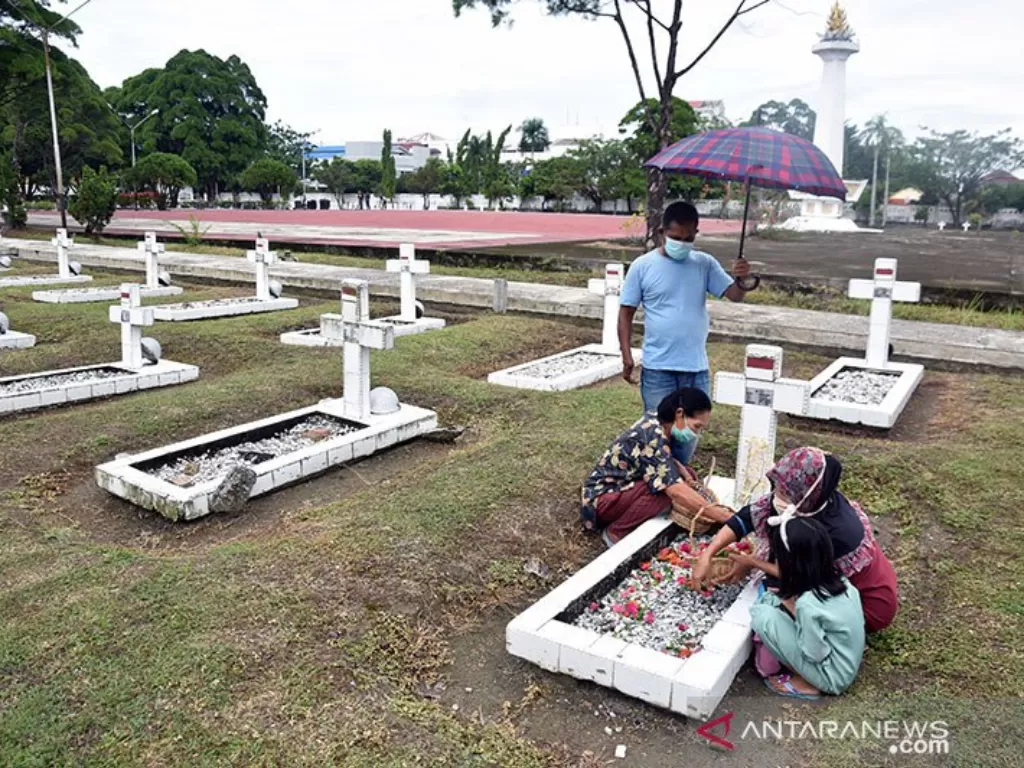 Warga mengenakan masker saat berziarah ke makam keluarganya di Taman Makam Pahlawan Kusuma Dharma, Kota Pekanbaru (ANTARA/FB Anggoro)
