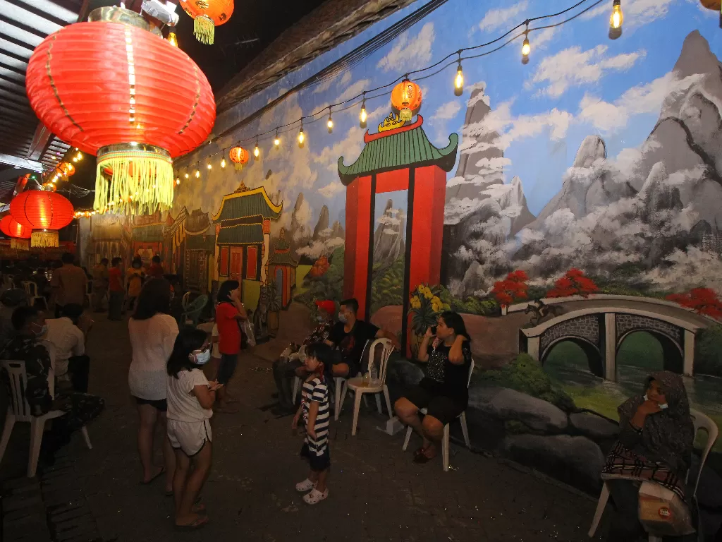 Pengunjung berada di salah satu gang kampung yang dihias dengan mural bernuansa Tionghoa (ANTARA FOTO/Moch Asim)