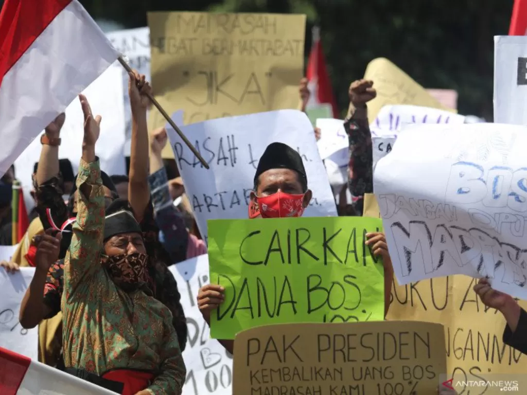 Sejumlah guru dan Kepala Madrasah swasta se-Kediri membentangkan poster saat unjuk rasa di kantor Kementerian Agama di Kediri, Jawa Timur, Kamis (5/11/2020).  (photo/ANTARA FOTO/Prasetia Fauzani)
