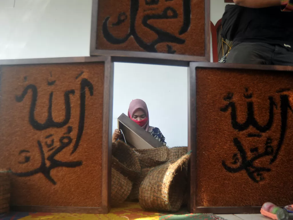 Perajin mengerjakan pembuatan kaligrafi dari sabut kelapa (ANTARA FOTO/Iggoy el Fitra)