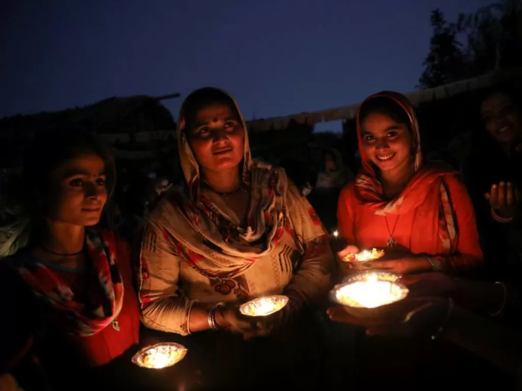 Pengungsi di Pakistan menyalakan lilin pada malam perayaan Hari Deepavali 2020. (Reuters/Anushree Fadnavis)