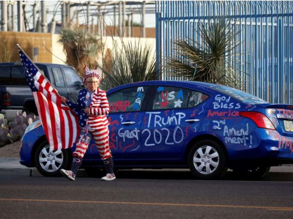 Seorang pendukung Donald Trump melakukan aksi protes usai kekalahan dalam Pilpres AS 2020 di Phoenix, Arizona, AS, Kamis (12/11/2020). (REUTERS/Jim Urquhart)