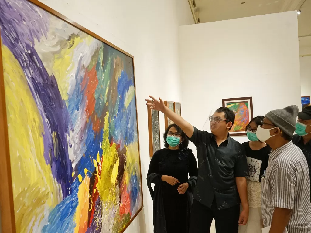Pelukis muda Indonesia, Gary Hadameon (kedua kiri) bersama keluarga mempresentasikan karyanya (ANTARA FOTO/Andreas Fitri Atmoko)
