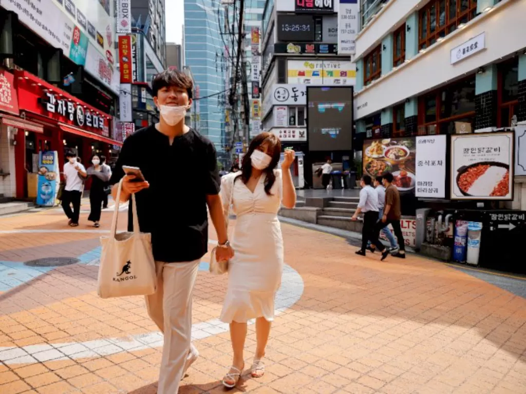 Warga Gangnam, Seoul berjalan menggunakan masker. (REUTERS/Kim Hong-Ji)